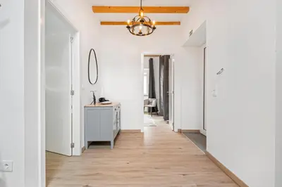 a hallway with white walls and a chandelier at Villa Pomar, By OP in Senhora do Rosário