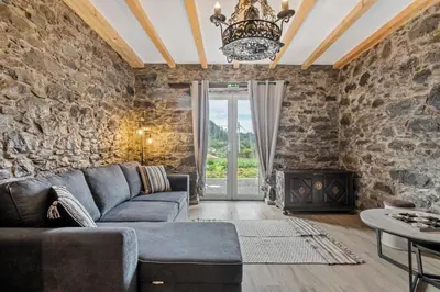 a living room with a couch and a stone wall at Villa Pomar, By OP in Senhora do Rosário