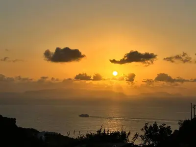 a sunset over the ocean with a ship in the water at Prestige Solmar - Sea View Apartment - Free covered parking - Caniço Center in Caniço