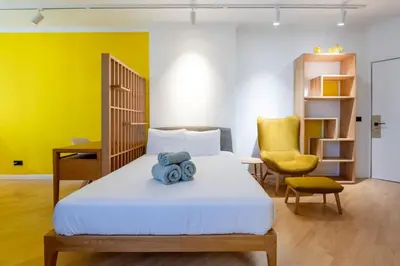 a bedroom with a bed and a yellow wall at Yellow Sun Studio - Cozy Stay in Central Funchal in Funchal