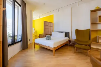 a bedroom with a bed and a chair and a window at Yellow Sun Studio - Cozy Stay in Central Funchal in Funchal