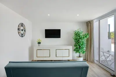 a living room with a couch and a tv on a wall at Studio Casa Belavista in Gaula
