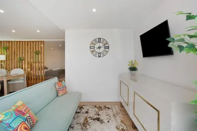 a living room with a couch and a clock on the wall at Studio Casa Belavista in Gaula