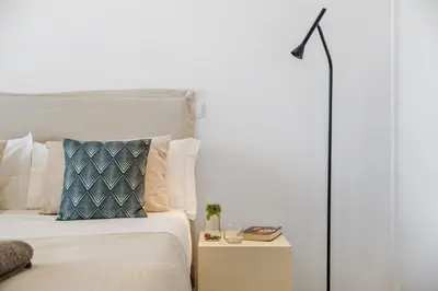 a bed with a blue pillow and a night stand at Villa Wiktoria, by Pausa Holiday Rentals in Ribeira Brava