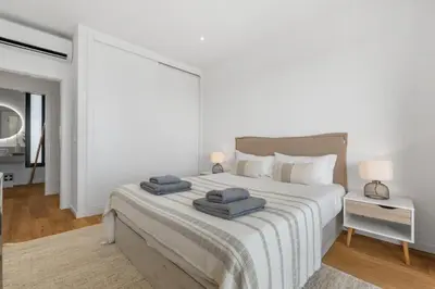 a white bedroom with a large bed with towels on it at Villa Wiktoria, by Pausa Holiday Rentals in Ribeira Brava