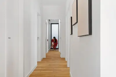 a woman walking down a corridor in a white hallway at Villa Wiktoria, by Pausa Holiday Rentals in Ribeira Brava