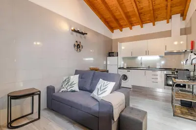 a living room with a blue couch and a kitchen at Cantinho da Deolinda in Luz