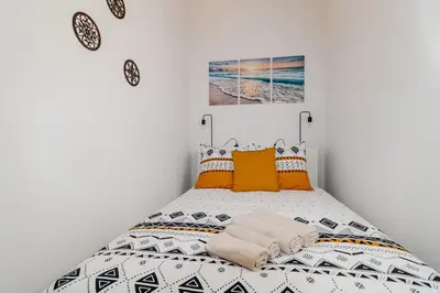 a bedroom with a bed with orange and white pillows at Cantinho da Deolinda in Luz