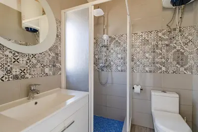 a bathroom with a toilet and a sink and a shower at Cantinho da Deolinda in Luz