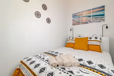 a bedroom with a bed with yellow and black pillows at Cantinho da Deolinda in Luz