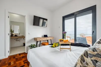 a bedroom with a bed and a table with flowers on it at The SPOT in Funchal