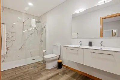 a white bathroom with a toilet and a shower at Casa das Raposinhas V, Funchal in Funchal