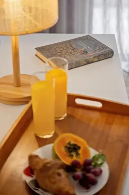 a table with a plate of food and two glasses of orange juice at Casa das Raposinhas V, Funchal in Funchal