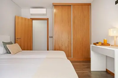 a bedroom with a bed and a wooden cabinet at Casa das Raposinhas V, Funchal in Funchal