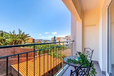 a balcony with a table and chairs and a view at Bright Modern 2BR Apartment Near Cristo Rei in Caniço