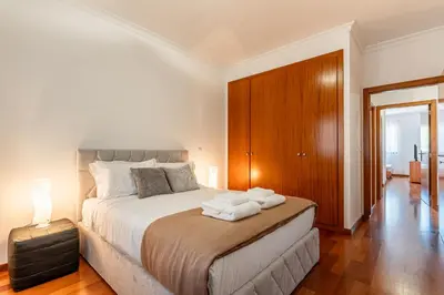 a bedroom with a bed with towels on it at Bright Modern 2BR Apartment Near Cristo Rei in Caniço