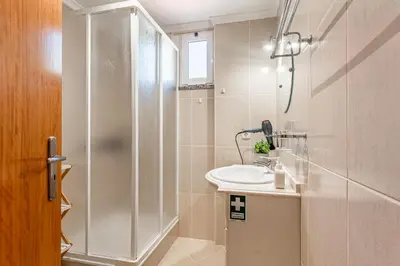 a bathroom with a shower and a sink at Bright Modern 2BR Apartment Near Cristo Rei in Caniço