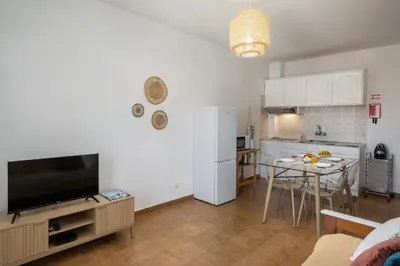 a living room with a television and a kitchen with a table at Porto Santo Beach & Golf Apartment - Sun Refuge in Porto Santo