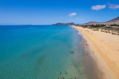 an aerial view of a beach with people in the water at Porto Santo Beach & Golf Apartment - Sun Refuge in Porto Santo