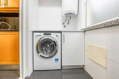 a white washer and dryer in a kitchen at Ti Clara in Caniço