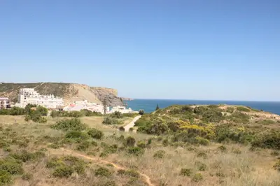 a house on a hill next to the ocean at Sea View Suite with Balcony and Pool - Praia da Luz in Luz