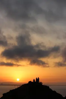 a group of people standing on a rock at sunset at Sea View Suite with Balcony and Pool - Praia da Luz in Luz
