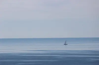a sailboat in the middle of a large body of water at Sea View Suite with Balcony and Pool - Praia da Luz in Luz