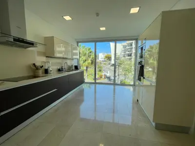 a large white kitchen with a large glass door at Suite 107 in Funchal