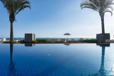 a large swimming pool with palm trees in the background at Suite 107 in Funchal
