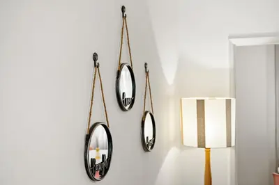 two mirrors hanging on a wall with a lamp at Live, Love and Laugh in Funchal