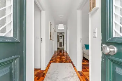 a hallway with a green door and a rug on the floor at Live, Love and Laugh in Funchal