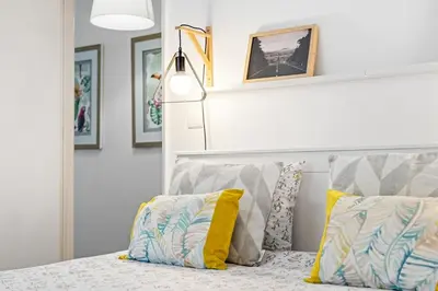 a bedroom with a bed with yellow and blue pillows at Live, Love and Laugh in Funchal