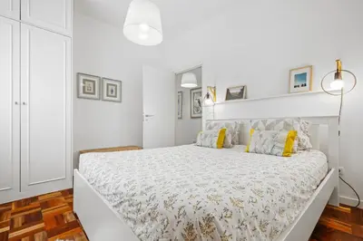 a white bedroom with a large white bed with yellow pillows at Live, Love and Laugh in Funchal