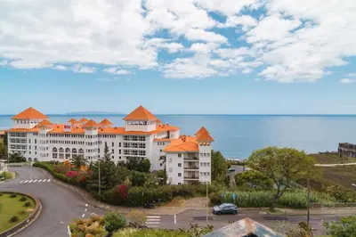 a view of a building with the ocean in the background at GuestReady - Caniço paradise with ocean view in Santa Cruz
