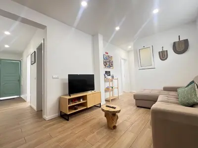 a living room with a couch and a television at Casa do Ribeirinho in Machico