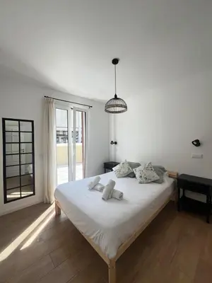a white bedroom with a bed with white sheets at Casa do Ribeirinho in Machico