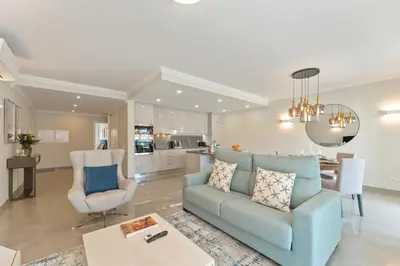 a living room with a blue couch and a kitchen at Casa Júlia, golfe piscina e praia in Lagos