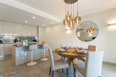 a kitchen and dining room with a table and chairs at Casa Júlia, golfe piscina e praia in Lagos