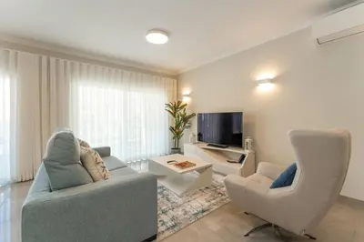 a living room with two chairs and a television at Casa Júlia, golfe piscina e praia in Lagos