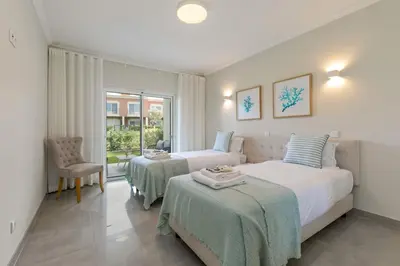 a bedroom with two beds and a window at Casa Júlia, golfe piscina e praia in Lagos