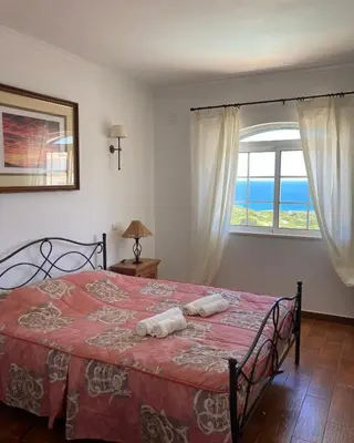 a bedroom with a bed with a view of the ocean at Sea View Suite with Pool - Praia da Luz in Luz
