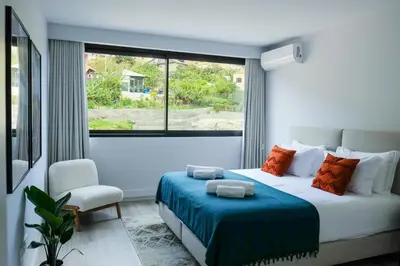 a bedroom with a bed with a blue blanket and a window at New 3 Bedroom Luxury Family Apartment - Airco, King Size Beds, Fully equipped kitchen, Balcony, Washingmachine, 2 bathrooms, Free parking, Fast Internet, 142m2 in Machico