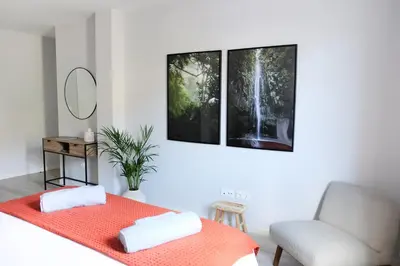 a bedroom with a bed and a chair and two pictures at New 3 Bedroom Luxury Family Apartment - Airco, King Size Beds, Fully equipped kitchen, Balcony, Washingmachine, 2 bathrooms, Free parking, Fast Internet, 142m2 in Machico