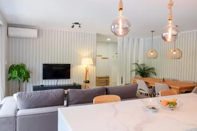a living room with a couch and a table at New 3 Bedroom Luxury Family Apartment - Airco, King Size Beds, Fully equipped kitchen, Balcony, Washingmachine, 2 bathrooms, Free parking, Fast Internet, 142m2 in Machico