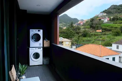 a balcony with a washer and dryer on it at New 3 Bedroom Luxury Family Apartment - Airco, King Size Beds, Fully equipped kitchen, Balcony, Washingmachine, 2 bathrooms, Free parking, Fast Internet, 142m2 in Machico