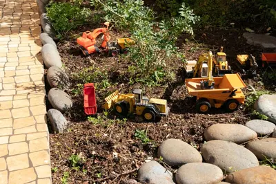 a garden with toy construction vehicles and rocks at Casa do Garajau 304 in Garajau