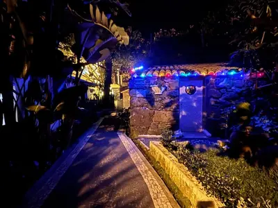 a house with christmas lights on a wall at Suite Bela Vigia 4 in Jardim do Mar