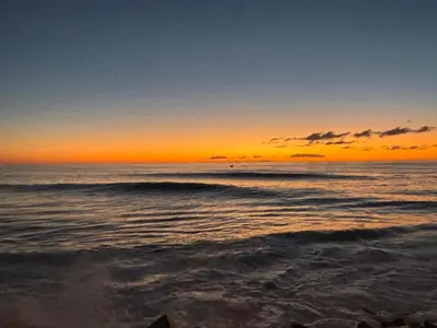 a sunset on the beach with the ocean at Suite Bela Vigia 4 in Jardim do Mar