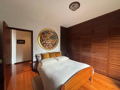 a bedroom with a bed and a painting on the wall at Suite Bela Vigia 4 in Jardim do Mar