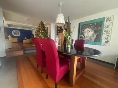 a dining room table with red chairs and a christmas tree at Suite Bela Vigia 4 in Jardim do Mar